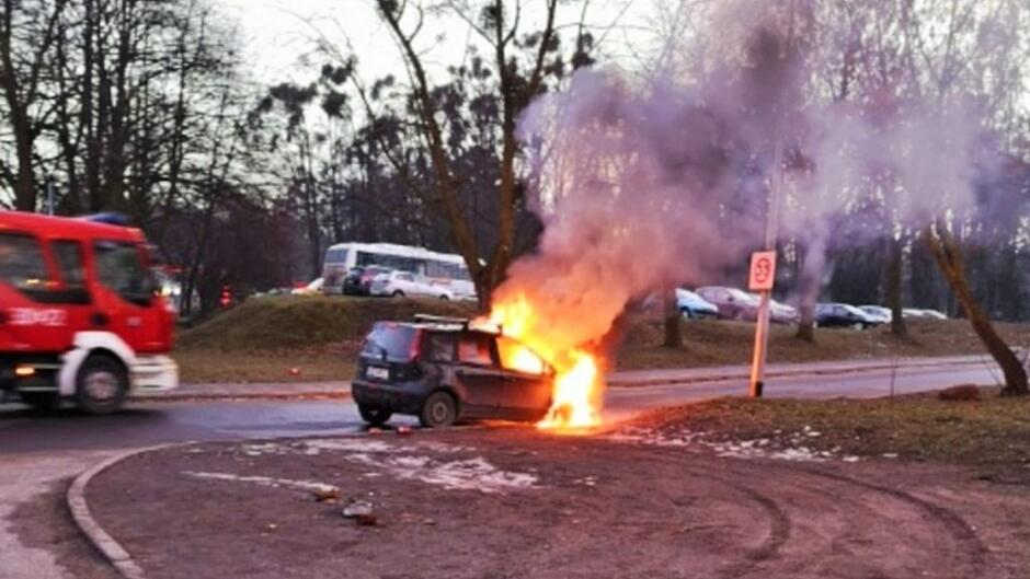 płonący samochód fiat Punto samochód Straży Pożarnej zaparkowane samochody ulica trawnik 