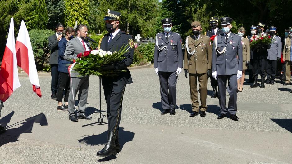 Strażnik z wieńcem cmentarz Łostowicki oficerowie flagi Polski drzewa goście składający kwiaty.JPG