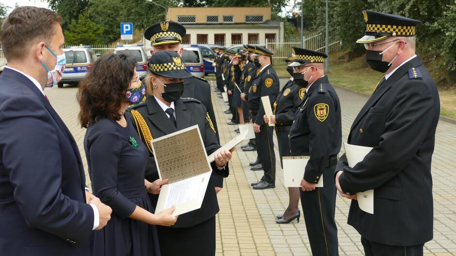 prezydent Gdańska zastępca prezydenta komendant straży miejskiej wyróznieni strażnicy radiowozy drzewa plac.JPG