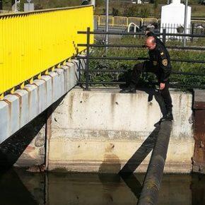 strażnik pochylony nad Kanałem Raduni żółta barierka na mostku ulica ołtarzyk przy drodze