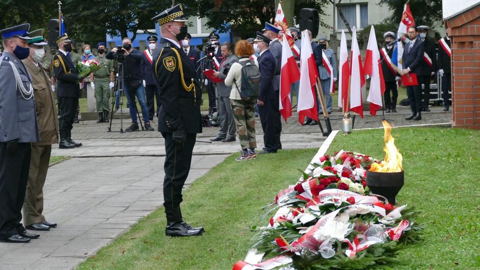 strażnicy kwiaty znicz delegacje flagi Polski mogiła pocztowców.JPG
