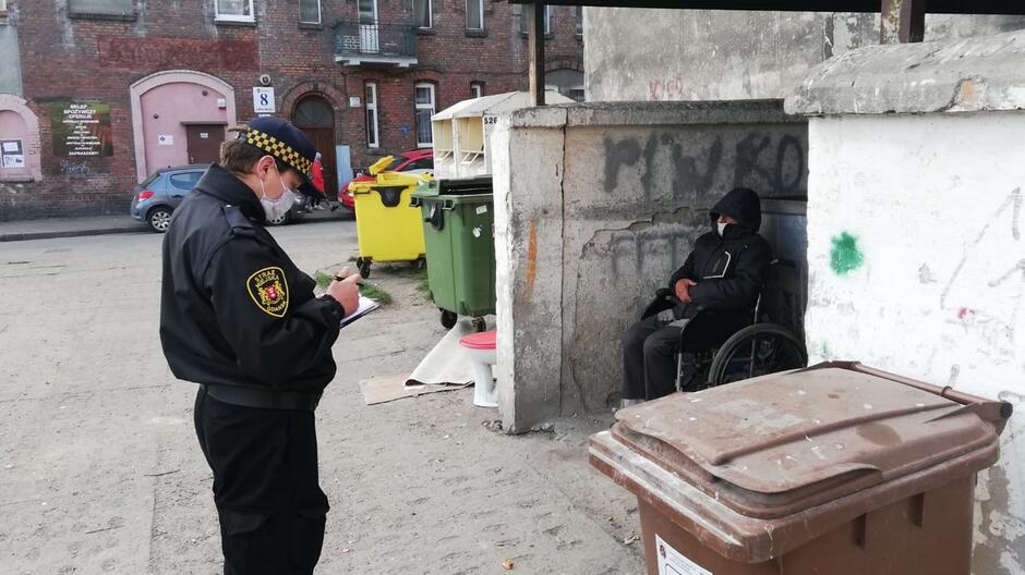Strażnik miejski bezdomny kontrola wiata śmietnikowa