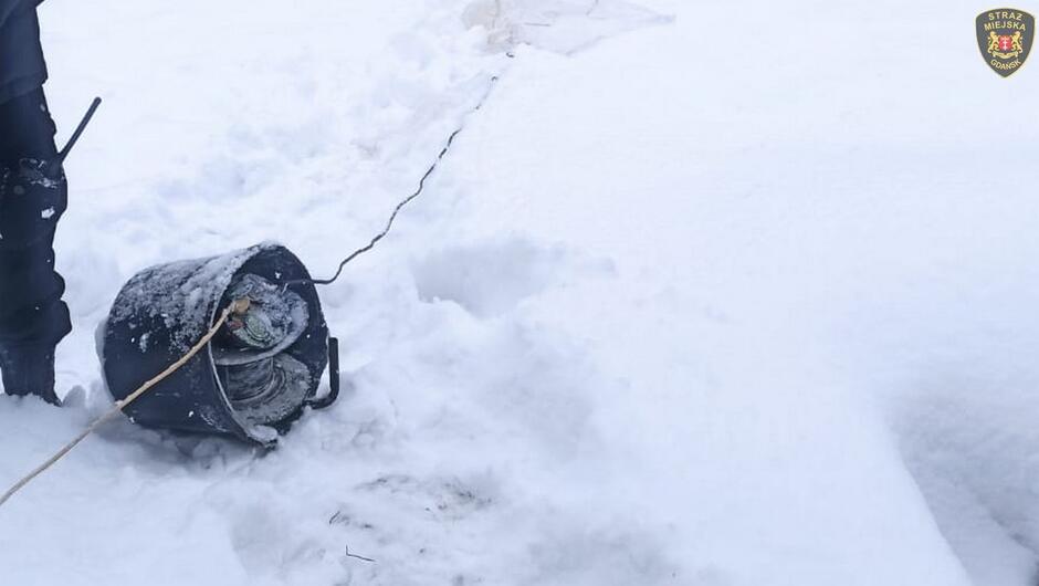 wiadro na śniegu z przedłużaczem elektrycznym fragment strażnika