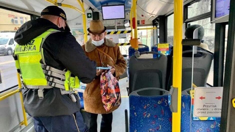 Sopocki strażnik miejski rozdaje maseczki w trolejbusie