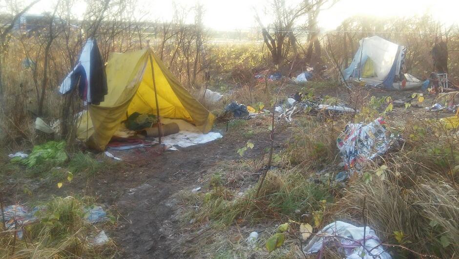 obozowisko osób bezdomnych namioty zarośla